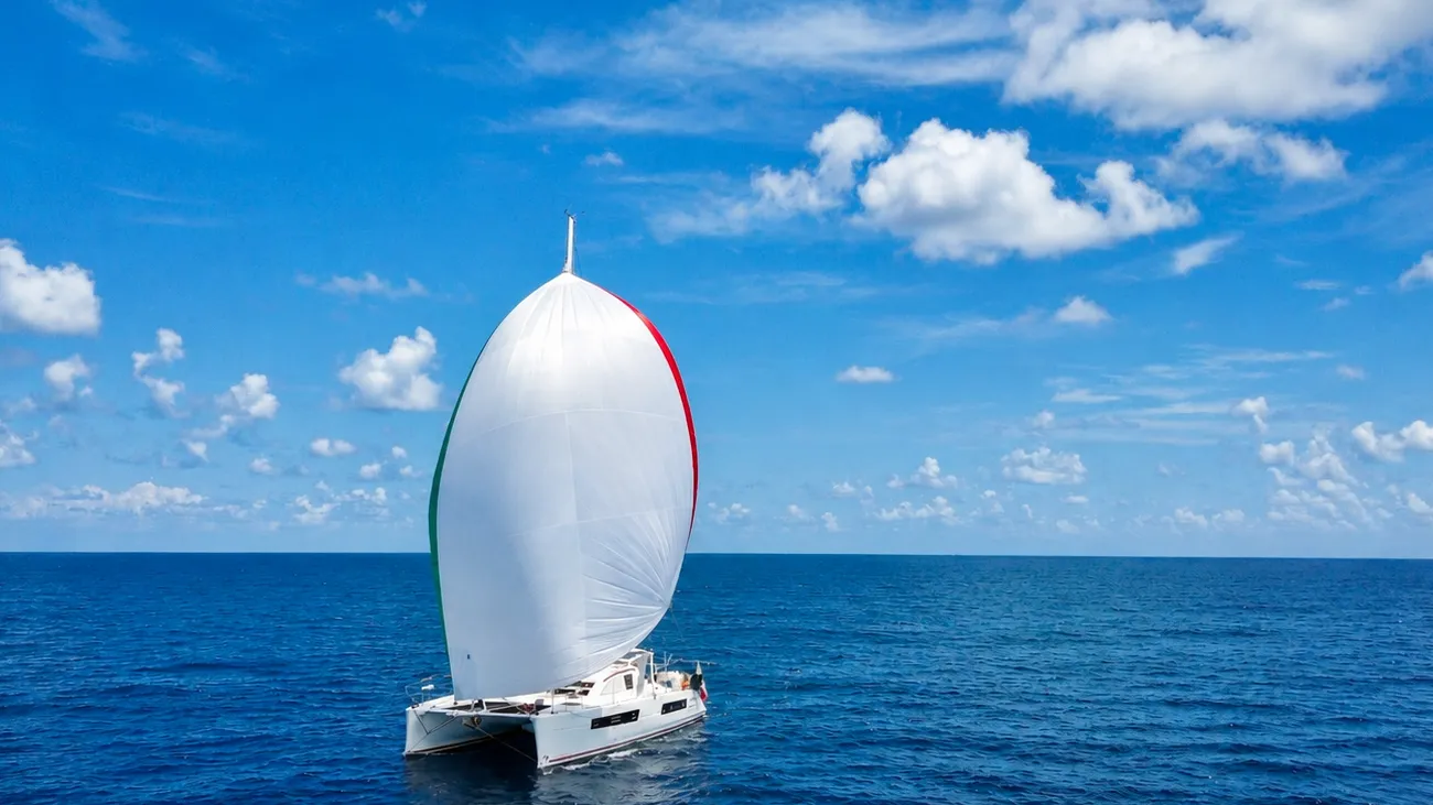 The Ikigai Catana 47 catamaran sailing under a full spinnaker on the open ocean