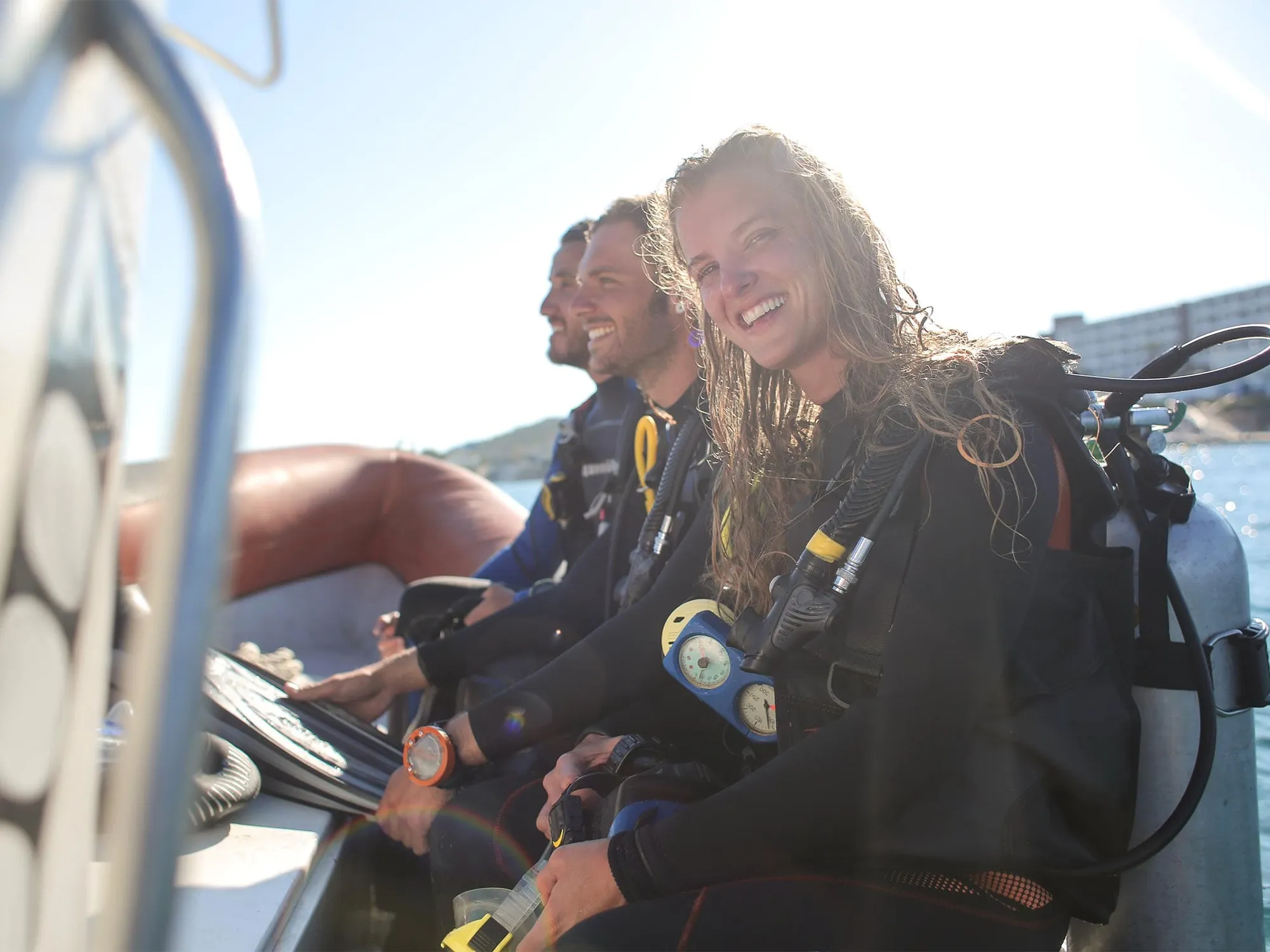 Smiling Ikigai crew on the tender in the sunlight after a dive